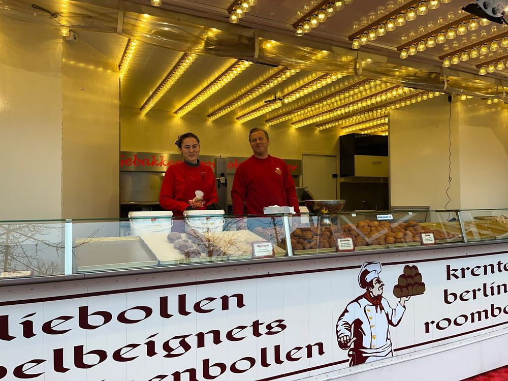 Twee medewerkers achter de vitrine van de kraam